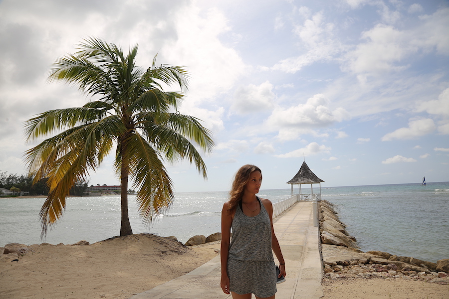 woman standing next to a palm tree